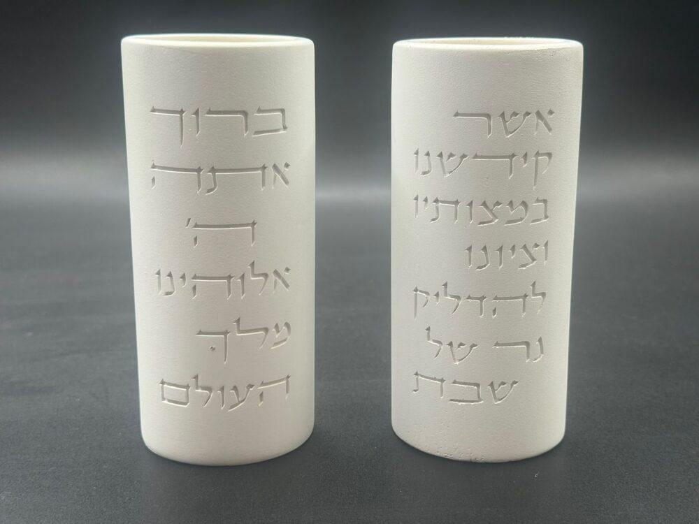 זוג פמוטים לבנים לשבת מבית הדריה עם ברכת הדלקת נרות בכיתוב לבן