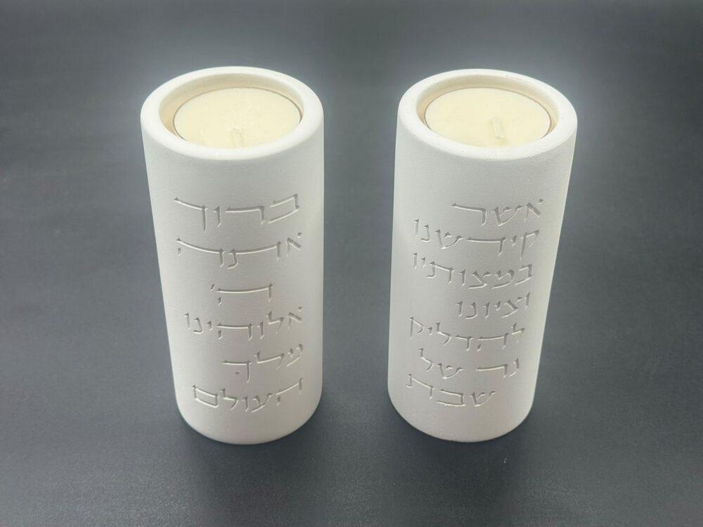 פמוט שבת לבן עם חריטת ברכת הדלקת הנרות בכיתוב לבן, מבט מקרוב